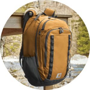 Brown and black backpack hanging on a post.